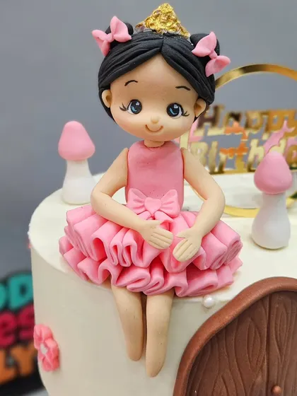 A close-up of the princess figurine sitting atop the floating tier of the "Princess to Queen" cake.