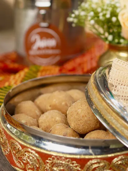 Our Atta Laddoos, packed in a traditional container. These are not just sweets, they are a warm hug on a cold day.