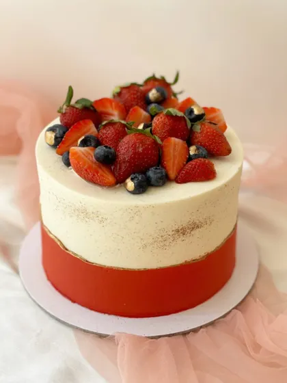 A duplicate image of the beautiful red and white two-tone cake, topped with fresh berries.