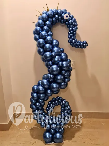 A stunning seahorse sculpture made from deep blue chrome balloons, with an evil eye detail. This is a perfect example of elegant and thematic balloon art.
