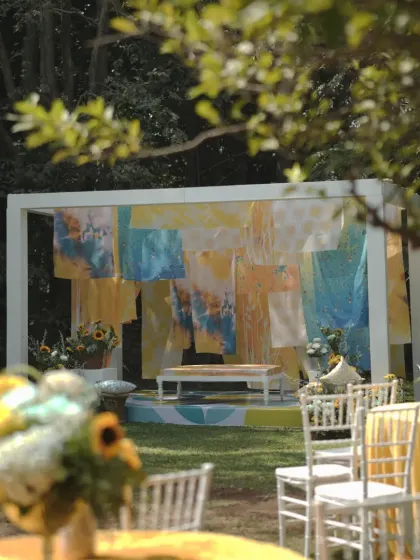 A wider view of the "Dhobi Ghat" Haldi venue, showing the main stage, guest seating, and the overall vibrant and sunny atmosphere.