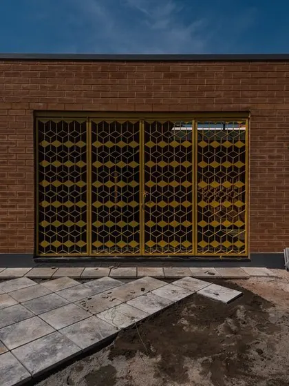 The bright yellow, pivoted steel gate we designed for the Good Bricks Company office. The geometric pattern was inspired by the shape of their bricks, creating a strong brand identity right at the entrance.