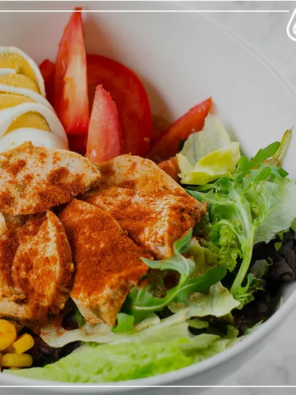 A beautiful salad with grilled chicken, hard-boiled eggs, corn, and fresh greens. This is what a power-packed, nutrient-dense lunch looks like.