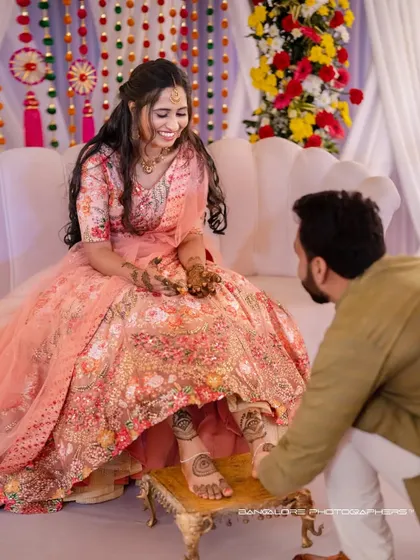 A sweet moment during the Mehendi ceremony. The groom's gentle gesture and the bride's happy smile tell a story of love and shared traditions.