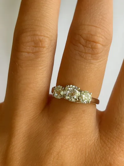 A closer look at the three-diamond ring, showcasing the brilliance and clarity of each stone. It is a piece that feels substantial yet elegant on the hand.