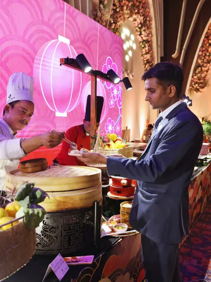 A guest being served directly from our live dim sum station. This direct interaction with the chefs adds a personal and engaging touch to the dining experience.