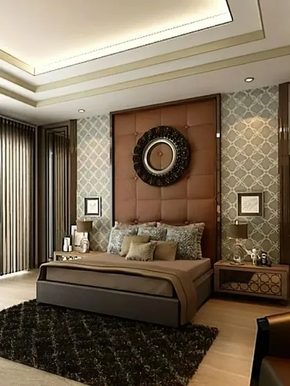 This master bedroom exudes classic elegance with a tufted leather headboard and ornate wallpaper. The layered lighting and rich textures create a warm, luxurious ambiance perfect for a restful escape.