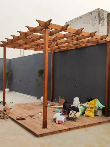 A look at the construction process. This image shows a classic wooden pergola with a raised deck being built, highlighting the solid craftsmanship that goes into every project.