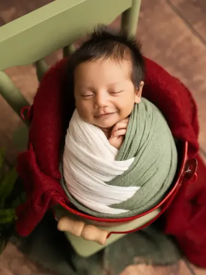 That sweet, sleepy smile is pure magic. Here, I used earthy green and white wraps to create a cozy, natural feel, highlighting the baby's joyful and peaceful expression.