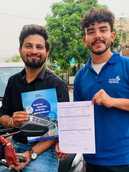Our team with a customer holding our solar agreement and booklet.