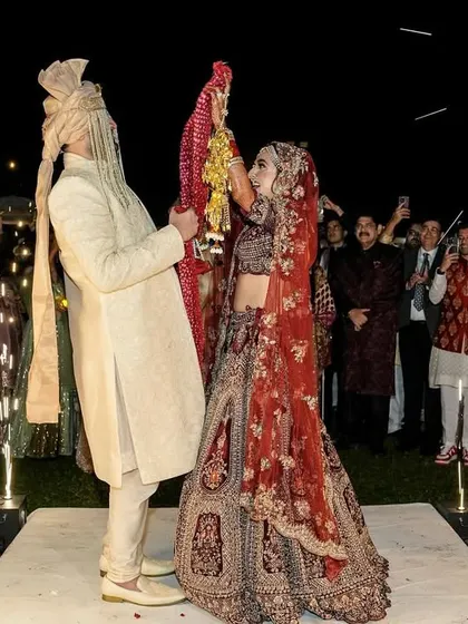 A classic Varmala moment, elevated with perfectly timed cold pyros. The sparks fly, literally, as the couple completes the ritual, surrounded by the cheers of their loved ones.
