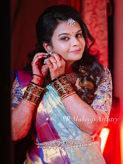A candid moment of Nithya getting ready. This shot captures the beauty of the final look, with glowing skin and defined eyes that perfectly match her traditional saree and jewelry.