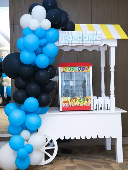 No party is complete without snacks. This classic popcorn cart, adorned with a blue and black balloon garland, was a huge hit with kids and adults alike at the rockstar-themed event.