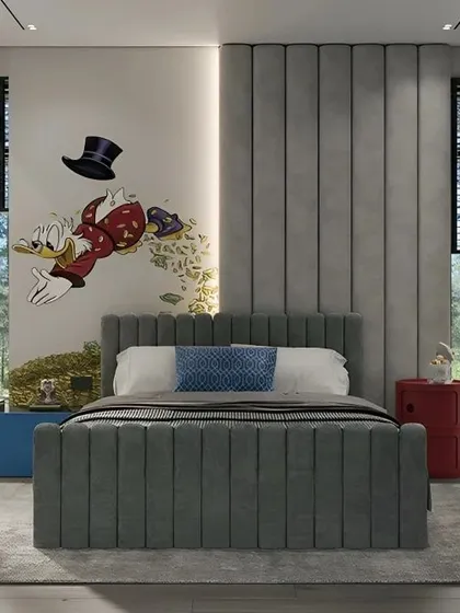 A fun and playful bedroom featuring a Scrooge McDuck wall mural. The channel-tufted grey bed and colorful side tables create a comfortable and vibrant space for a child to enjoy.