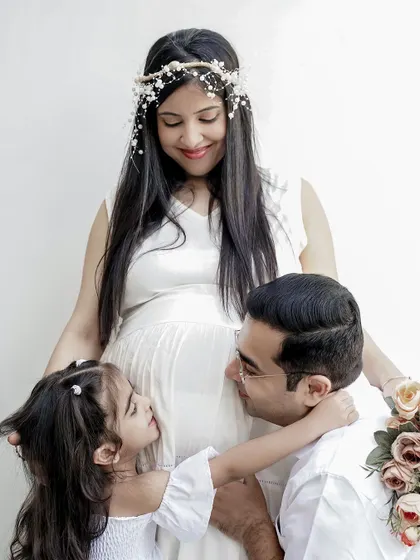 A heartwarming maternity photo with the whole family. The older sibling and father share a tender moment with the mother and her baby bump, celebrating the new life on the way.