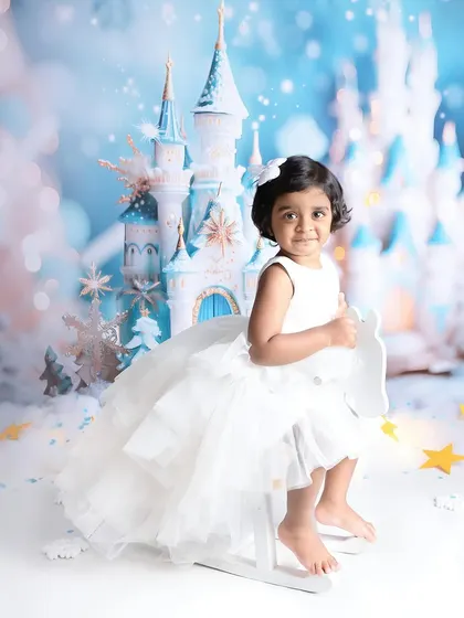 Another look at this magical winter castle scene. The soft, cool-toned lighting and the little girl's white dress create a beautiful and cohesive fairytale portrait.