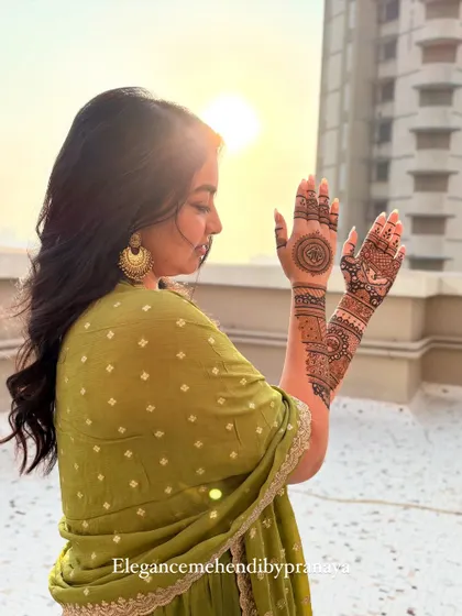 A candid shot of a bride enjoying the sunset with her fresh mehendi. The design is simpler, perfect for a more minimalist look.
