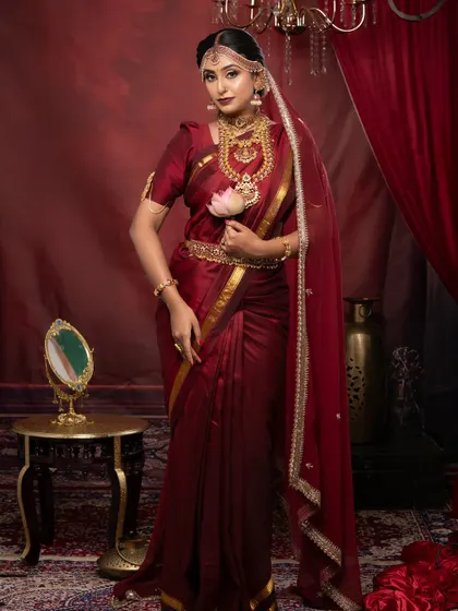 A full-length shot of a bride in a deep red Kanjeevaram saree, a look taught during our 25-day pro course.