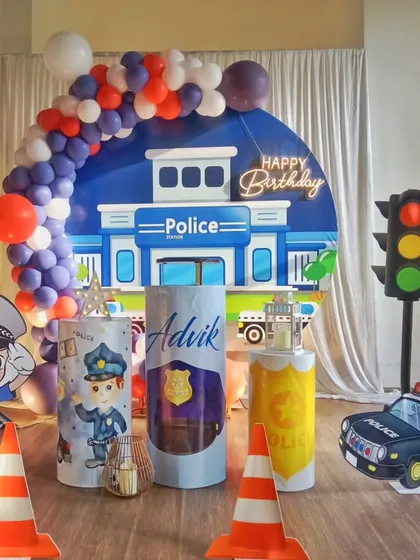 A fun and unique police-themed birthday party, complete with a police station backdrop, traffic light prop, and a little officer cutout.