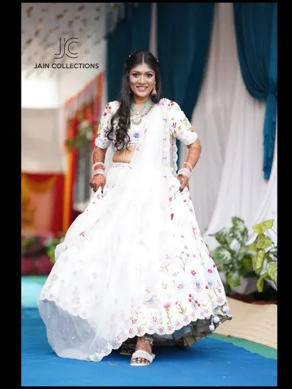 A client looking joyful and ready to twirl in the white floral lehenga. It's a lightweight and comfortable option for long functions.