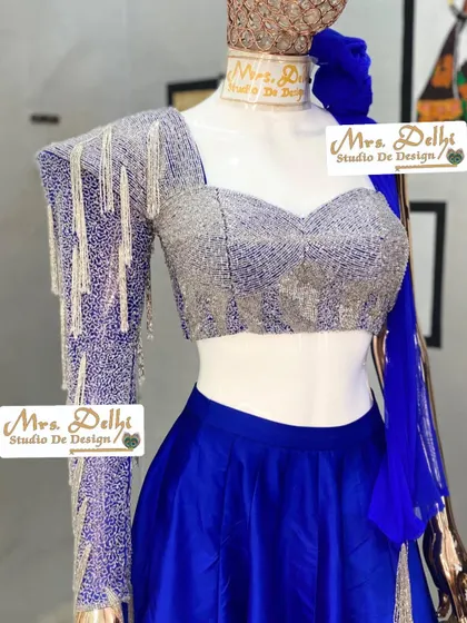 The full blouse of our hand-worked shoulder cowl lehenga choli. The combination of the sweetheart neckline and the single, heavily embellished sleeve creates a unique and modern bridal look.