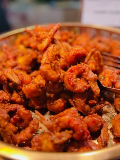 A generous serving of spicy and crispy Prawns Koliwada, a classic Mumbai seafood delicacy.