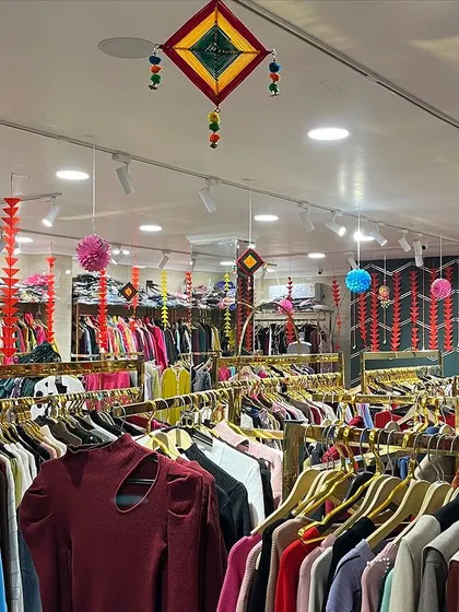 Another view of the Diwali store decoration, showing the colorful handmade wall hangings and paper pompoms suspended from the ceiling.