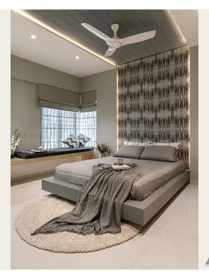 The bay window in this bedroom is transformed into a comfortable seating nook, perfect for reading or enjoying the view. The grey Roman blinds offer a clean, modern window treatment.