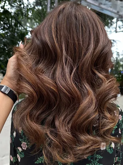A close-up of the 'Caramello' highlights, styled into soft waves.