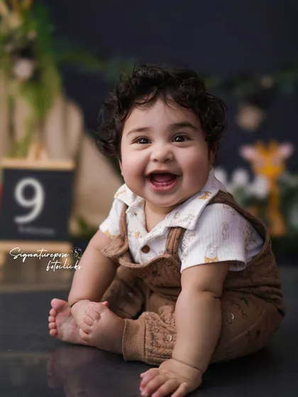 The biggest, happiest smile from our little explorer! This close-up shot from the jungle-themed session captures his delightful personality. I provide all the props, including the milestone marker.