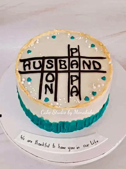 For the man in your life. This clever crossword-themed cake spells out 'Husband' and 'Papa', a sweet tribute to a beloved family man.