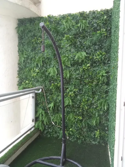Even a small balcony can become a cozy green corner. Here, I've installed a vertical garden wall and artificial grass flooring to create a private, lush retreat.