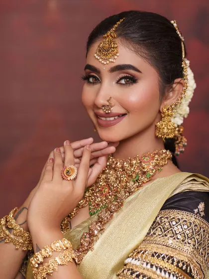 A classic pose that shows off the stunning necklace set and the detailed embroidery on the blouse sleeves.