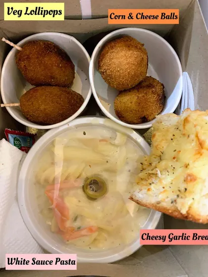 A close-up of the snack box with Veg Lollipops and White Sauce Pasta.