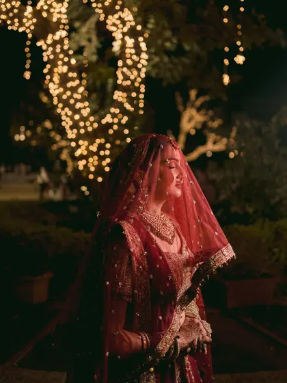 A beautiful shot of the bride under her veil, with the twinkling lights creating a magical atmosphere. This portrait is full of romance and quiet elegance.