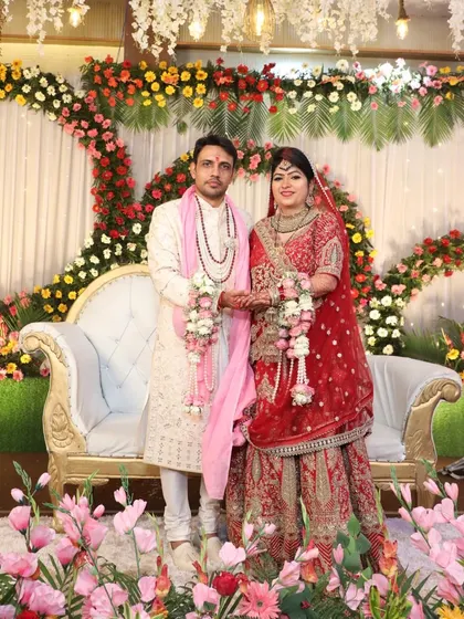 Richa and Puneet stand amidst a beautiful floral arrangement during their wedding reception. Their story, stretching from Himachal to Delhi, is a testament to how light-hearted conversations can blossom into a life of togetherness.