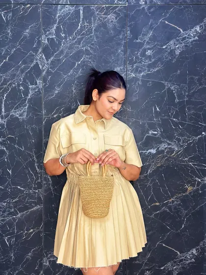 The details of the pleated dress and the woven texture of the bag complement each other beautifully.