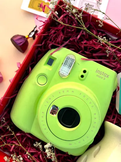 A close-up view of the contents of our Valentine's gift box, highlighting the vibrant color of the camera against the red shredded paper filling.