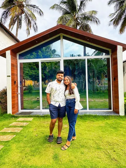 Another shot of a couple standing in front of our beautiful glass-fronted cabins, a perfect photo opportunity to remember your stay.