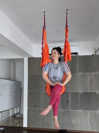 A student takes a moment to relax and smile in the hammock during a weekend aerial class.