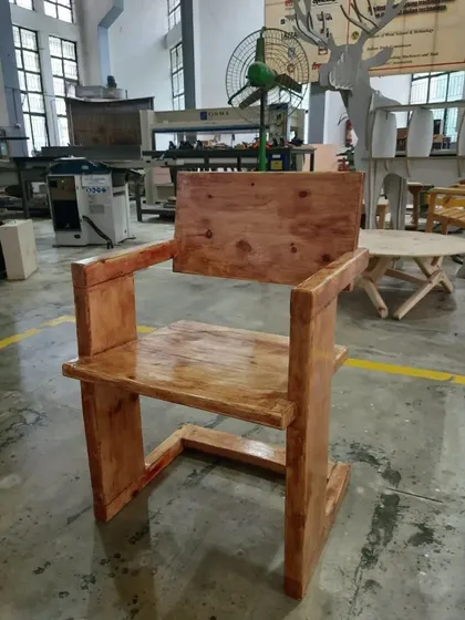 Another view of the finished minimalist chair, showing its sturdy construction and the rich color achieved through the finishing process.