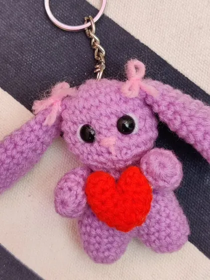 A purple bunny keychain holding a red heart.