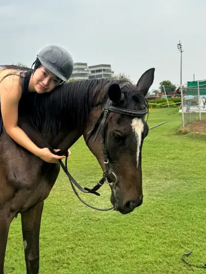 A rider gives her horse a hug after a lesson in the field. The bond is the most rewarding part of the journey.