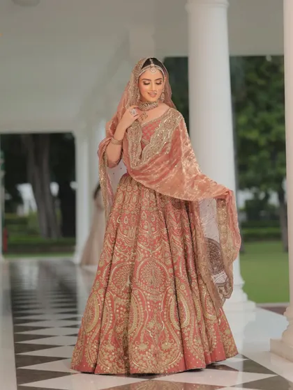 The bride's gentle smile and the flowing dupatta create a moment of pure grace. The color of this lehenga is perfect for a day wedding.