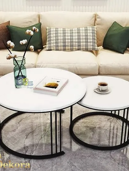 A set of two nesting tables with white tops and thin black metal legs. This versatile coffee table set is perfect for entertaining, providing extra surface area when needed and saving space when not in use.