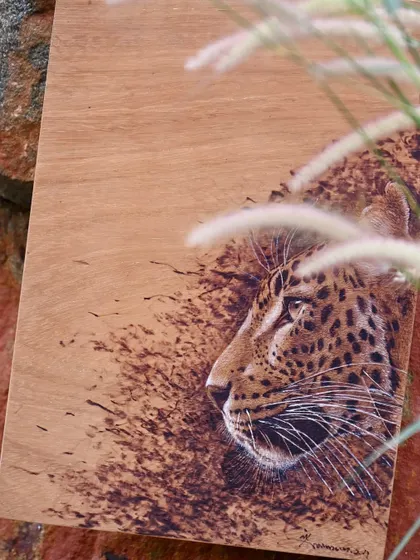 A pyrography portrait of a leopard, its calm yet alert expression captured in stunning detail. These unique artworks celebrate biodiversity and inspire a deeper connection with the animal kingdom.