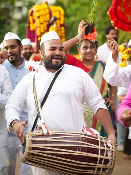 A devotee plays the dholak with great energy during the Ashadhi Ekadashi procession. Music and chanting are an integral part of our joyful celebrations.
