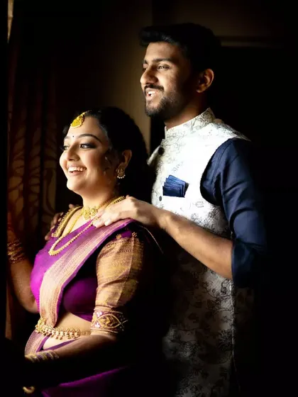 A happy couple sharing a moment by the window after their engagement ceremony, bathed in natural light.