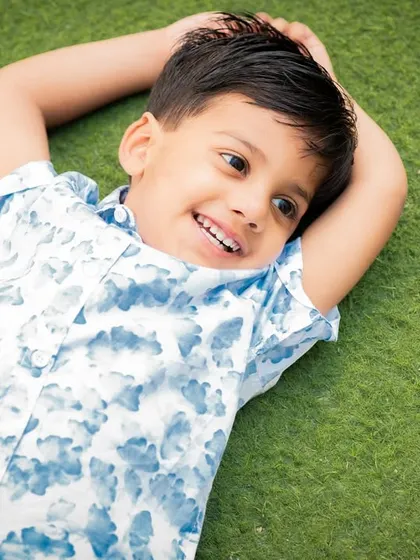 A relaxed and happy outdoor shot of a boy lying on the grass. These sessions are all about capturing genuine, carefree moments.