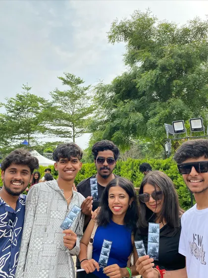 A group of friends enjoying the outdoor festival atmosphere with their photo strips.
